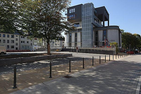 Ein modernes Gebäude mit Glasfassade und markanten schwarzen Elementen im Sonnenlicht