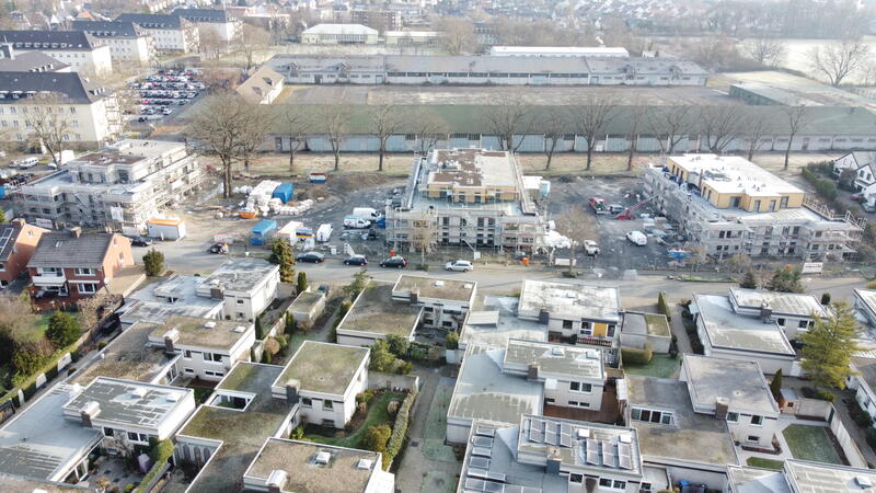 Eine Wohnsiedlung mit modernen Häusern und mehreren Baustellen in hellem Licht