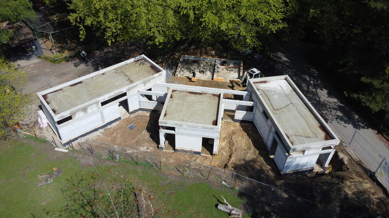 Luftaufnahme eines modernen weißen Gebäudekomplexes mit flachem Dach im Grünen