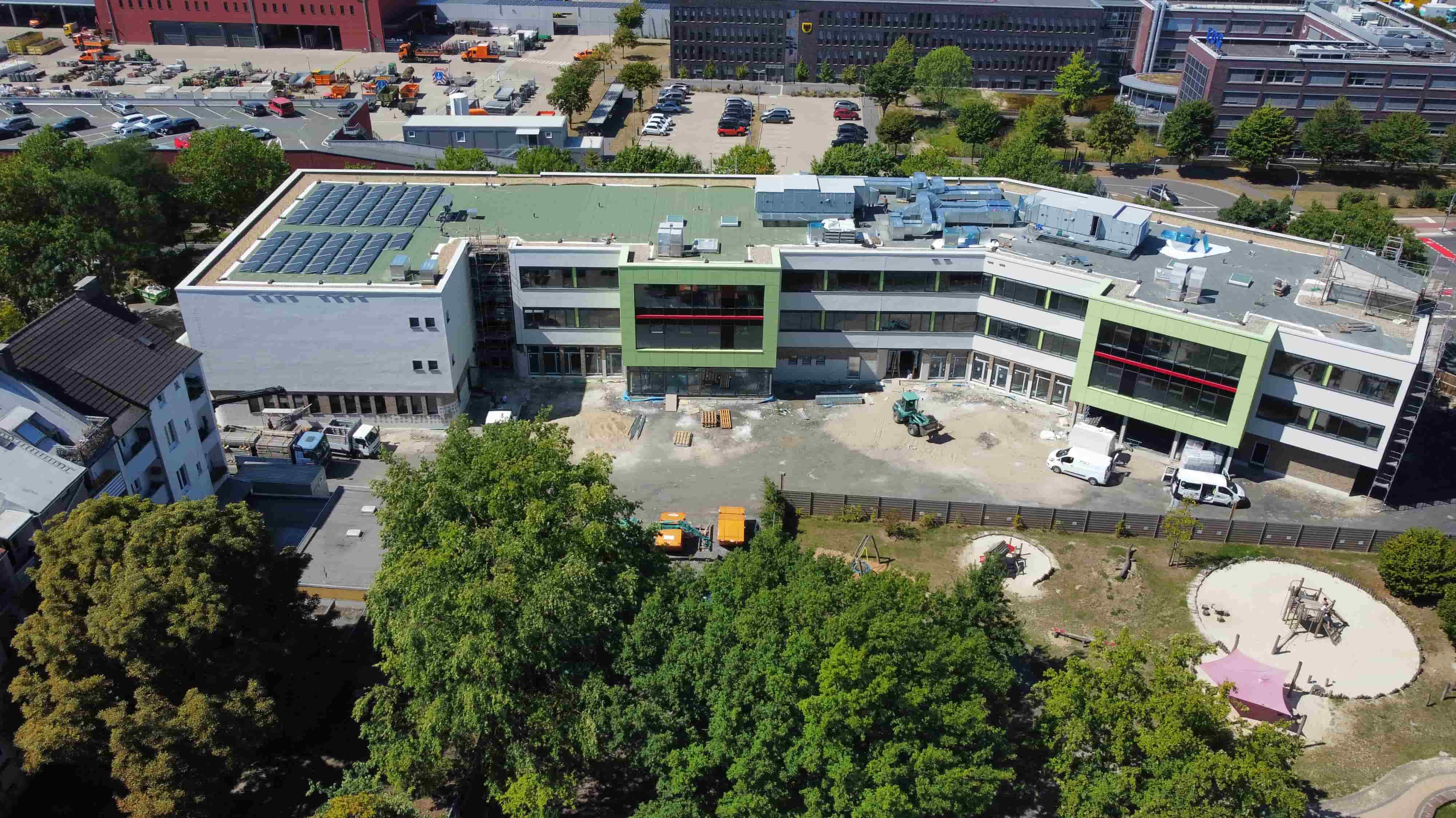 Ein modernes weiß-grünes Gebäude mit Flachdach und rechteckigen Fenstern im Bau