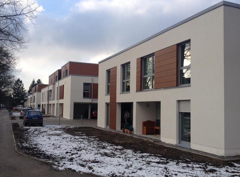 Mehrere moderne, zweistöckige Wohngebäude mit weißen und braunen Fassaden im Winter